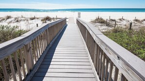 A wooden boardwalk leading to a sandy beach with clear blue water. - Turtle Cay Golf Villa Edgewater Beach Resort (Panama City Beach)
