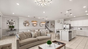 A modern living room with a sofa, coffee table, and decorative mirrors.