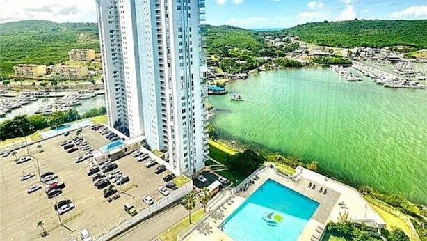 A high-rise hotel with a swimming pool and marina.