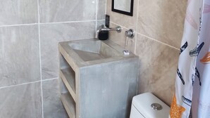 Ein Badezimmer mit Toilette, Holzwaschbecken, Spiegel und einer Duschvorhang mit Sternmotiv.