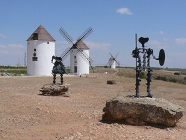 Un molino de viento y una réplica de molino en un entorno rural.