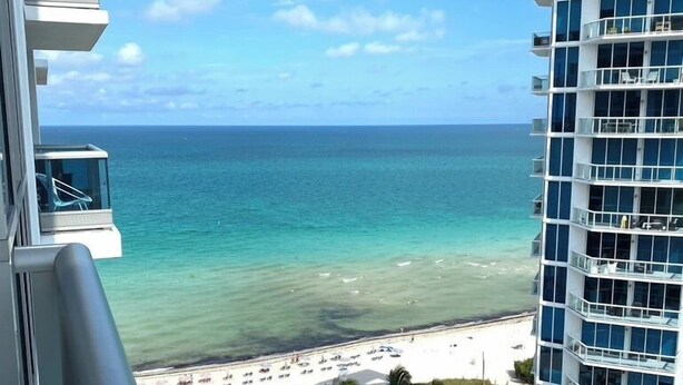 Un hôtel de grande hauteur doté de nombreux balcons donnant sur une plage.