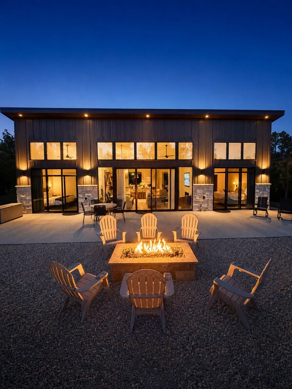 A modern two-story building with a fire pit and outdoor seating.