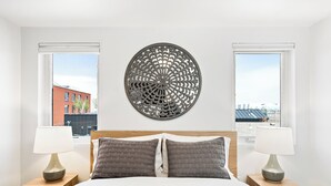 Una camera da letto moderna con un letto grande, due comodini con lampade e un elemento decorativo sopra il letto.