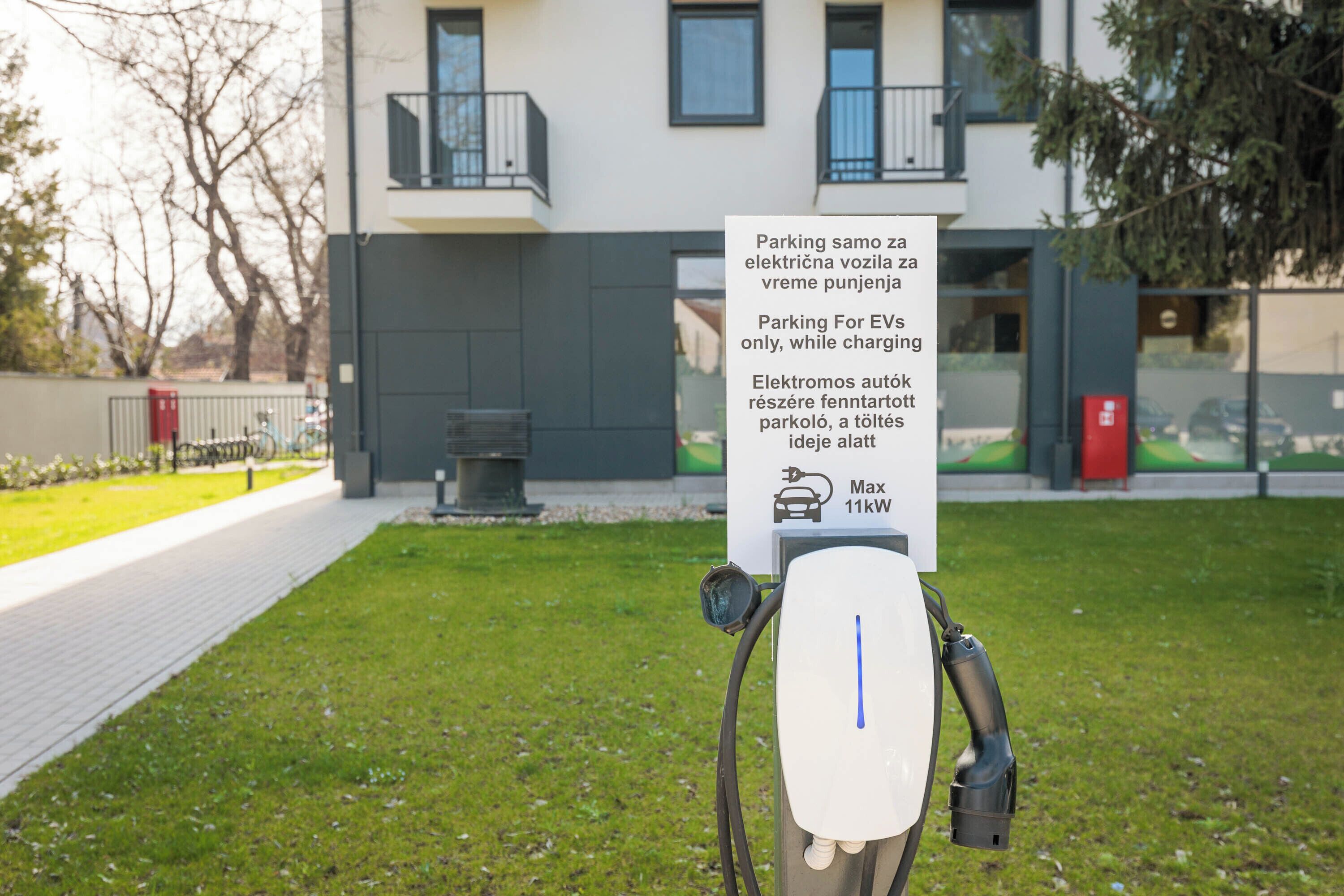 An electric vehicle charging station with a sign indicating it is for EVs only and has a 11kW charging capacity.