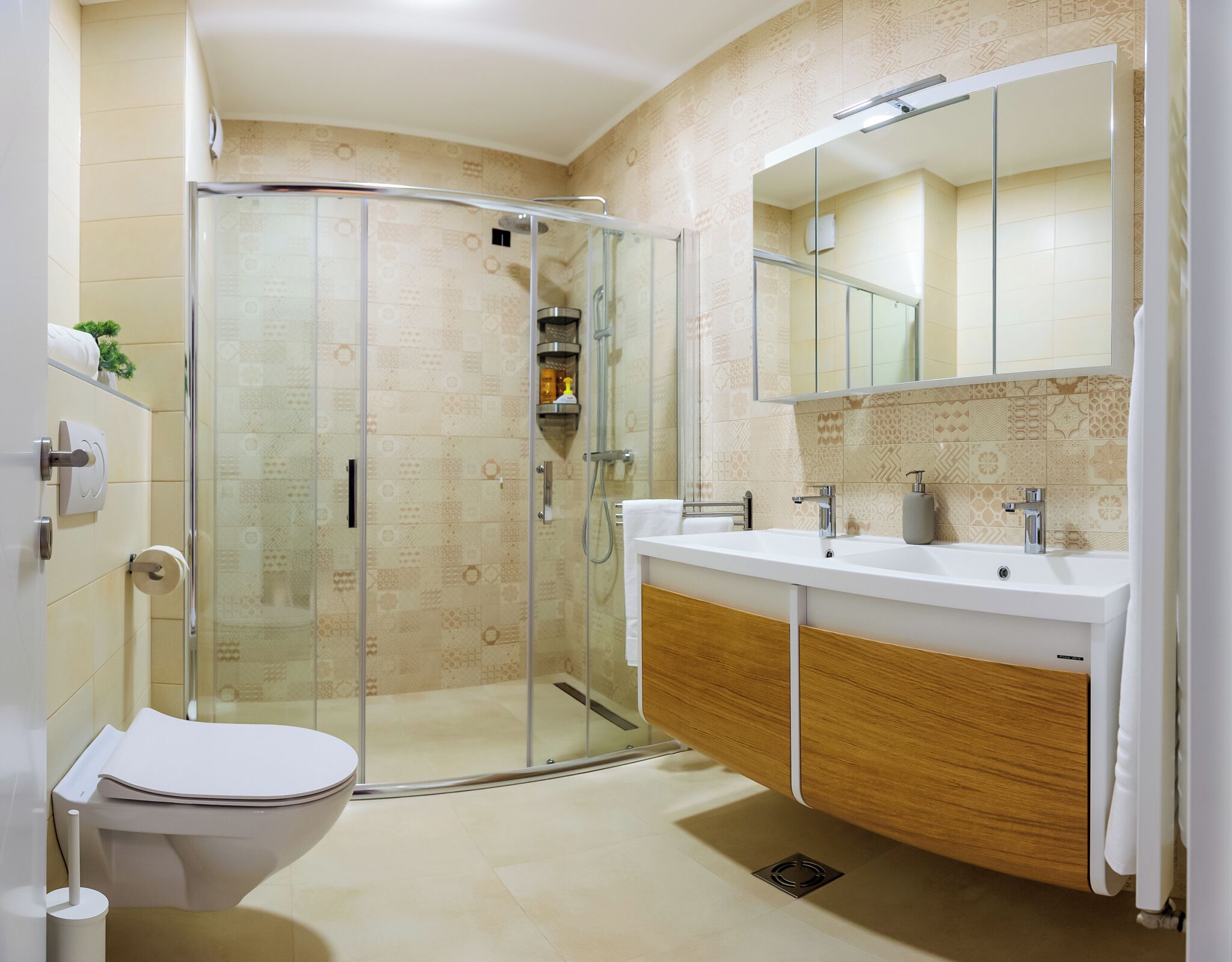 A modern bathroom with a glass shower enclosure, a white toilet, and a vanity with a mirror.