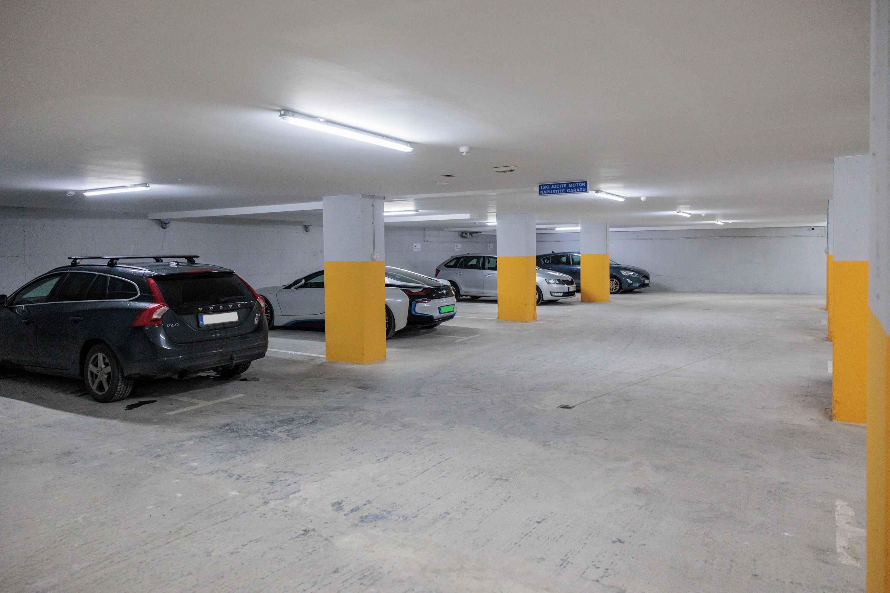 Eine mehrgeschossige Tiefgarage mit Betonböden und gelben Säulen.