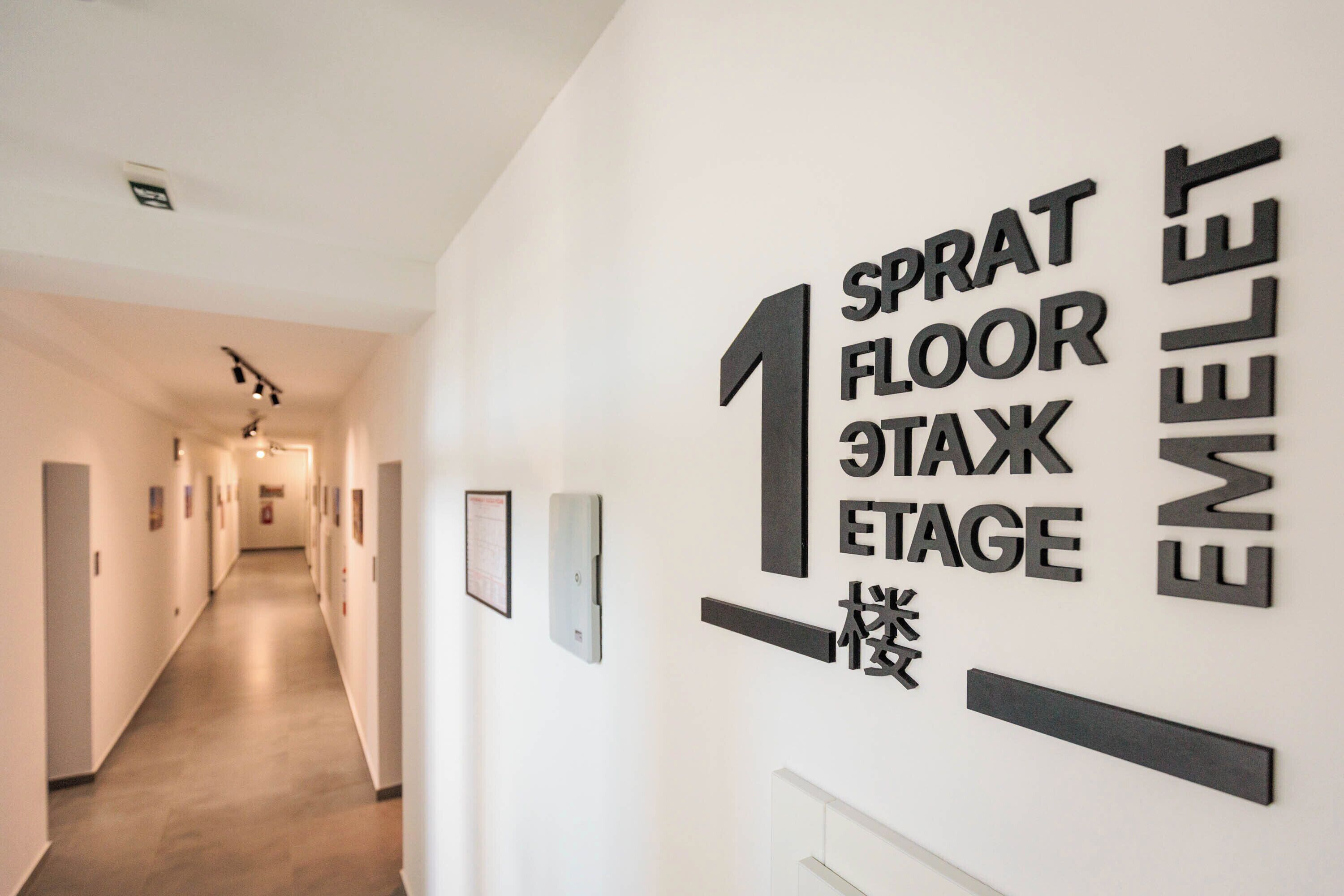 A hallway with a sign indicating 'Sprat Floor 1 Tax Stage' and 'Emelett'.