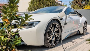 A white sports car parked on a paved driveway. - TESLA Residence Subotica (Subotica)