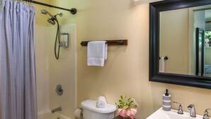 A bathroom with a bathtub, toilet, sink, and a mirror. - Private Updated Studio Close to Volcanoes National Park (Volcano)