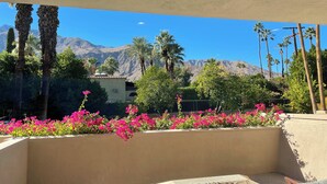 A balcony with a view of mountains, palm trees, and pink flowers. -  2 BR Chic Mid Century located in the heart of Palm Springs w/ stunning pool (Palm Springs)