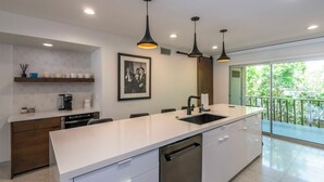 A modern kitchen with white countertops, a built-in dishwasher, and pendant lighting. -  2 BR Chic Mid Century located in the heart of Palm Springs w/ stunning pool (Palm Springs)