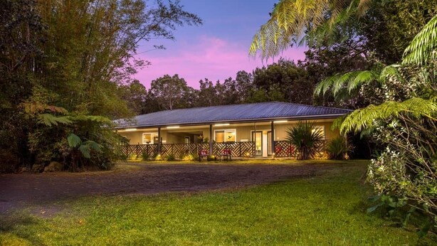 A two-story house with a covered porch and a fenced yard. - Whole House Rental- Modern Two-Unit Bungalow (Volcano)