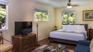 A bedroom with a bed, a television, a desk, a chair, and a sofa. - Whole House Rental- Modern Two-Unit Bungalow (Volcano)