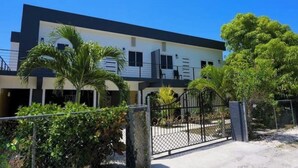 A modern two-story building with a black and white facade, surrounded by greenery and a gated entrance. - Williams Manor [Across From Ricks Cafe Negril] (Negril)