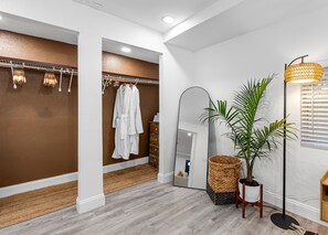 Bathroom features a large mirror, towel rack, and wooden cabinet.
