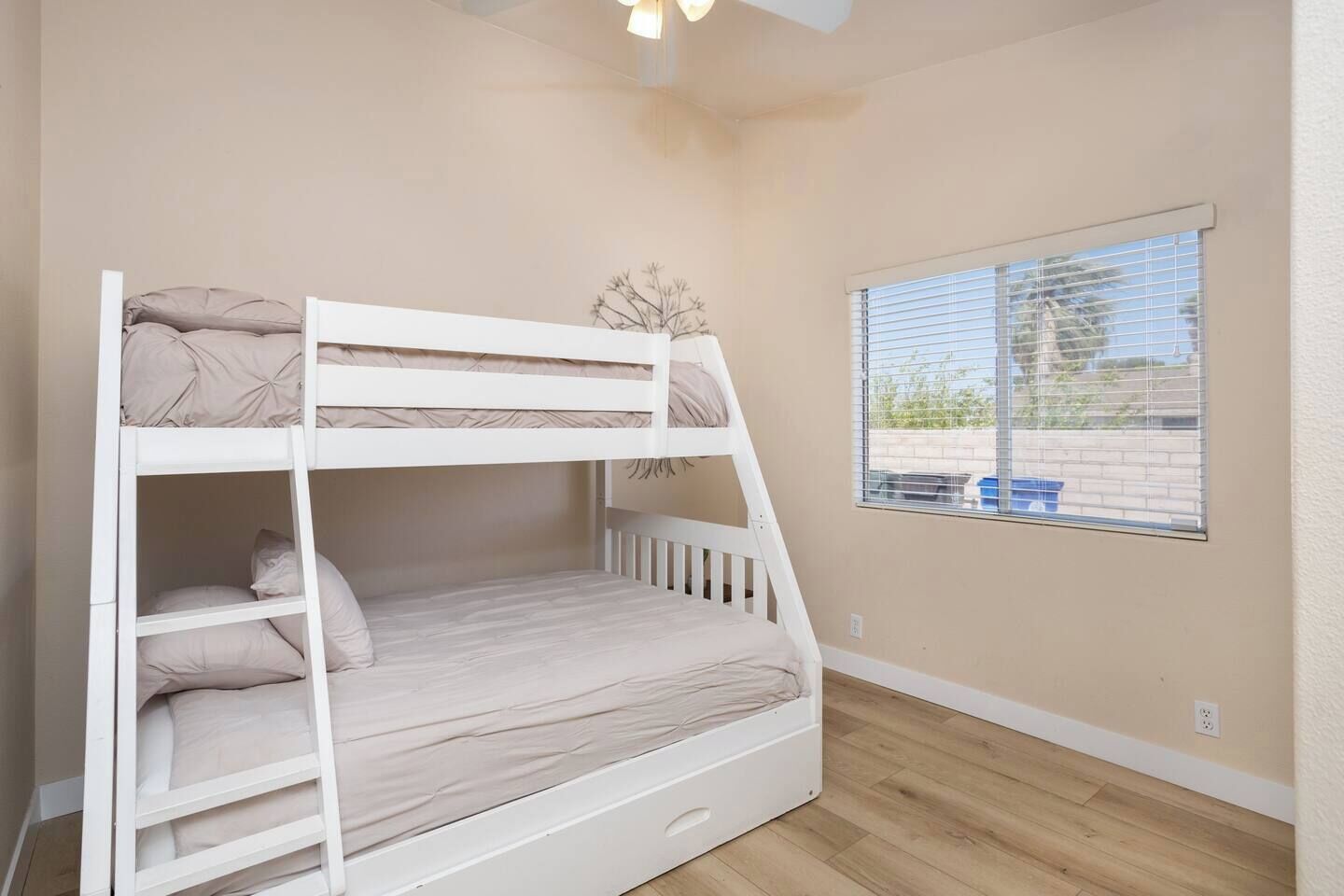 A bunk bed in a room with a window and a view of the outside.