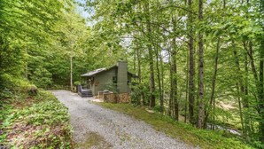 A rustic cabin with a gravel path leading to it, surrounded by dense forest. - Rushing Creek Retreat, Serene Cabin with Great Views! (Sylva)