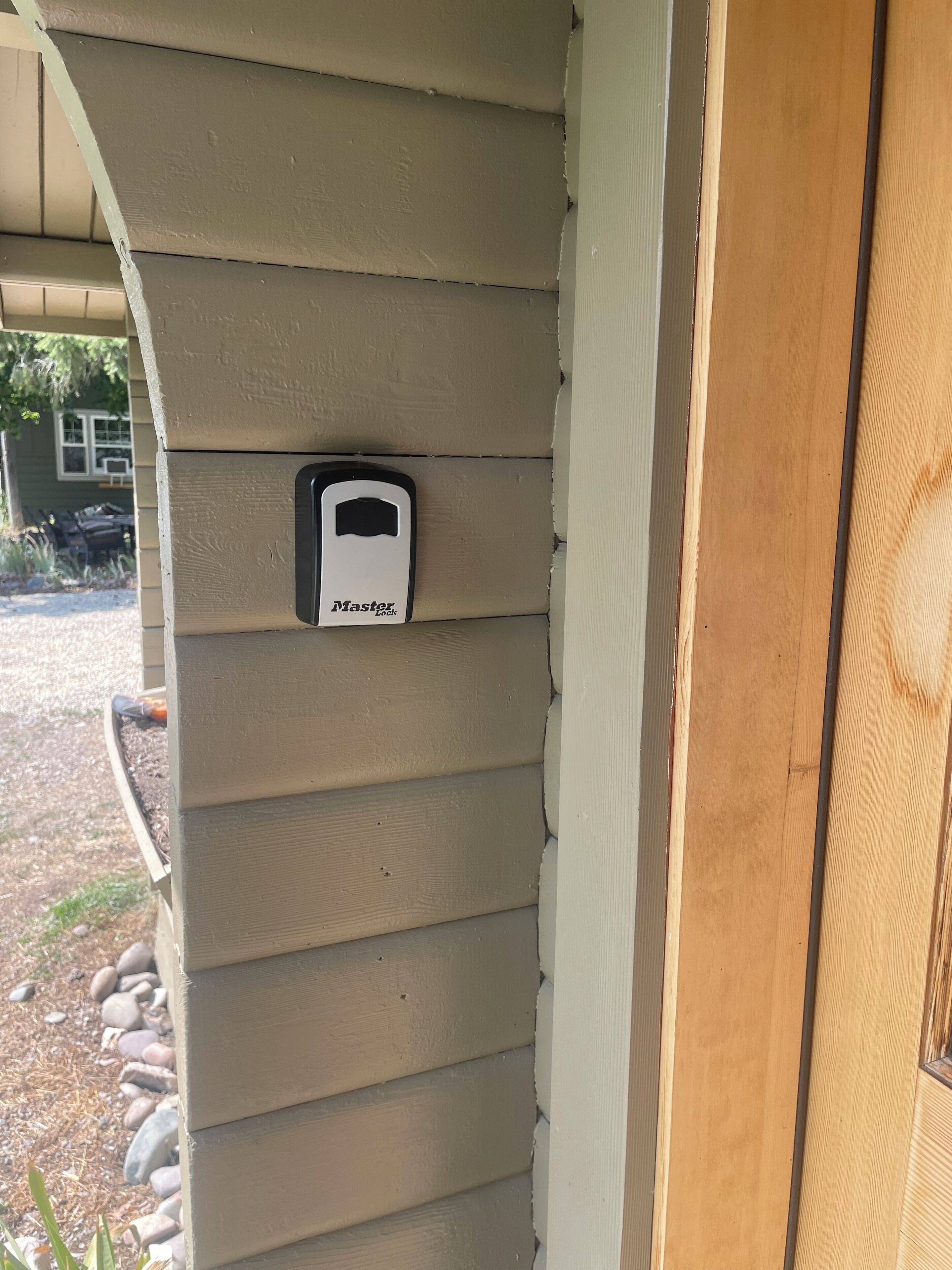 A house exterior with beige siding, a wooden door, and a mailbox labeled "Master."