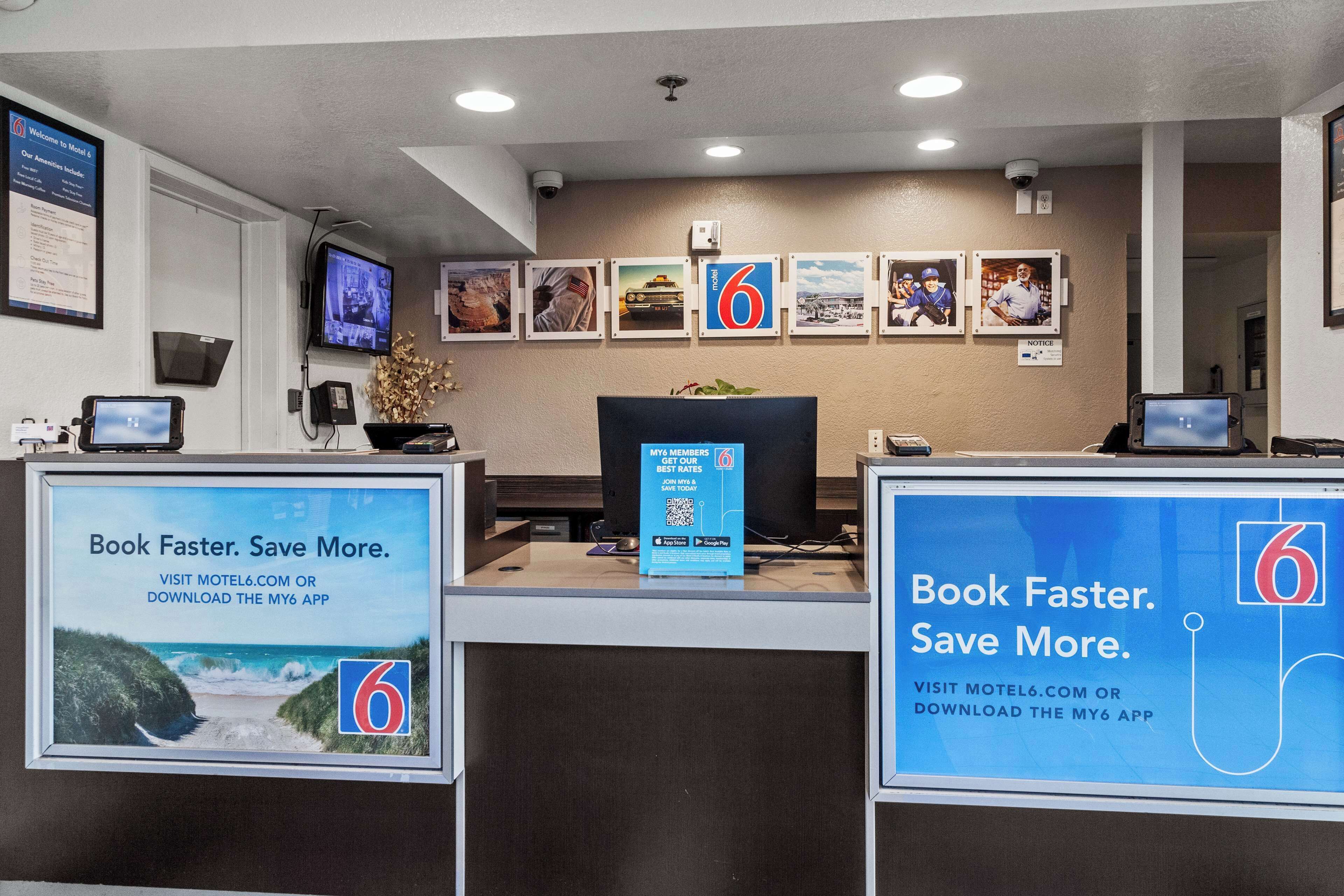 A reception desk with a sign promoting the My6 app for booking and saving on rates.