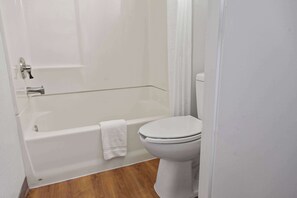 Bañera con ducha, toallas, jabón, papel higiénico