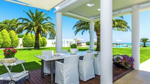 Relax on the patio with a clear view of the surrounding landscape, a wooden deck, and a table set for a comfortable dining experience.