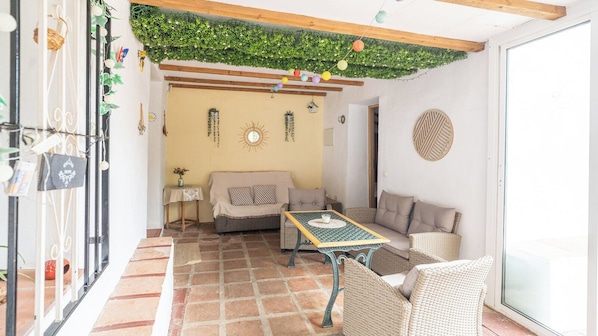 A cozy interior with a tiled floor, a sofa, a table, and wicker furniture. - Reiner Canillas de Albaida by Ruralidays (Málaga)