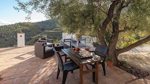 An outdoor patio with a chess table, seating, and a view of a hilly landscape. - Reiner Canillas de Albaida by Ruralidays (Málaga)