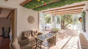An indoor patio area with wicker furniture, a table, and a view of the outdoors. - Reiner Canillas de Albaida by Ruralidays (Málaga)