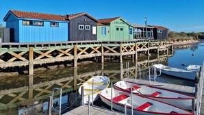 A wooden pier with colorful buildings and boats docked at the end.