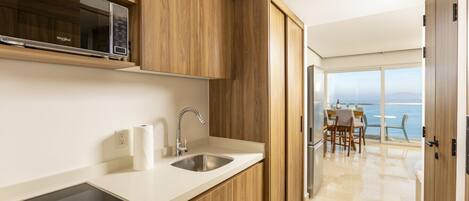A modern kitchen with wooden cabinets, a stainless steel sink, and a built-in stove.