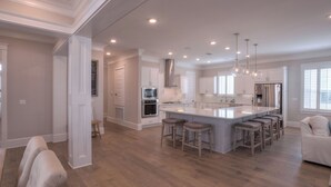 A spacious kitchen with a large island, modern appliances, and a bar area.