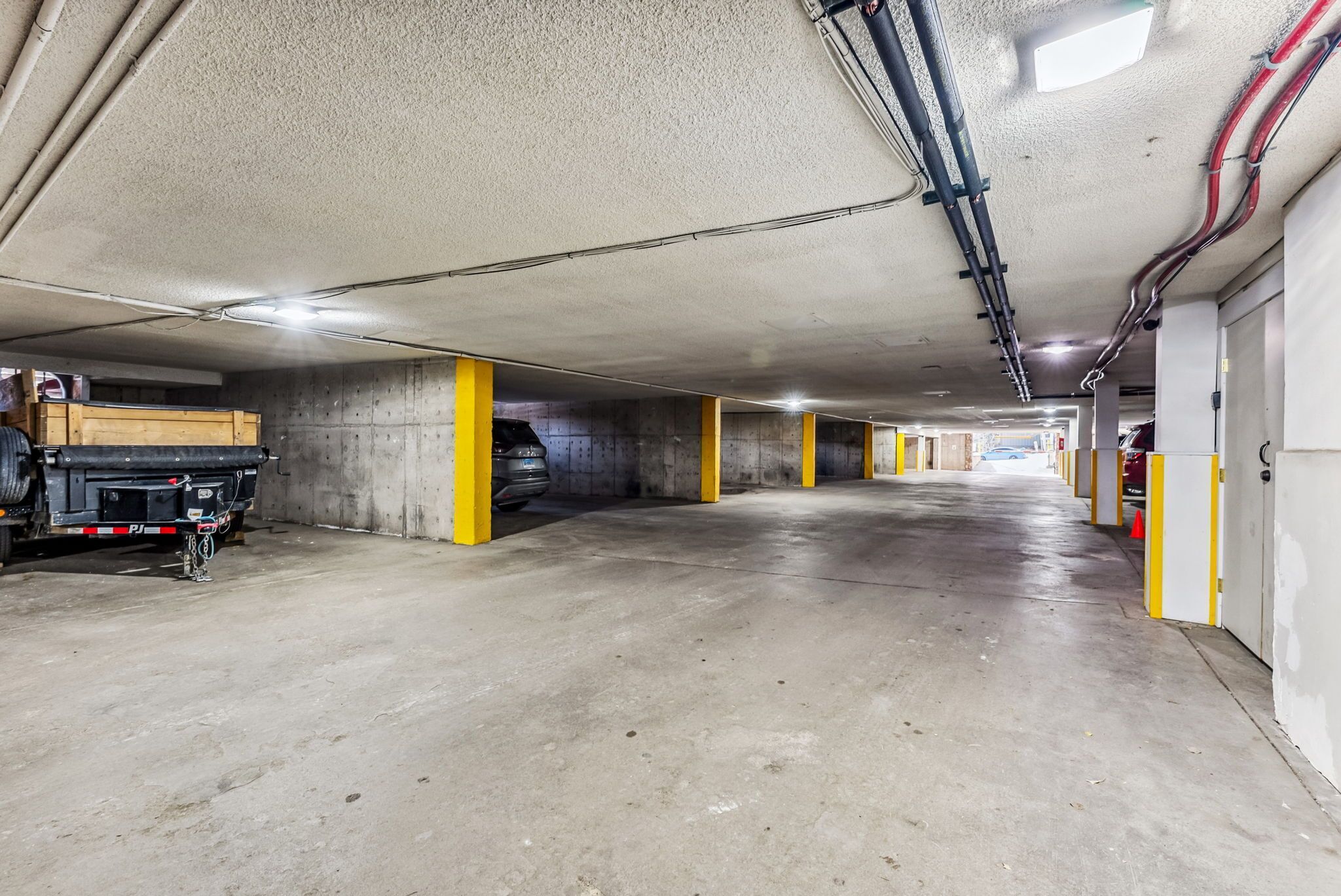 Eine mehrstöckige Parkgarage mit Betonböden und gelben Säulen.