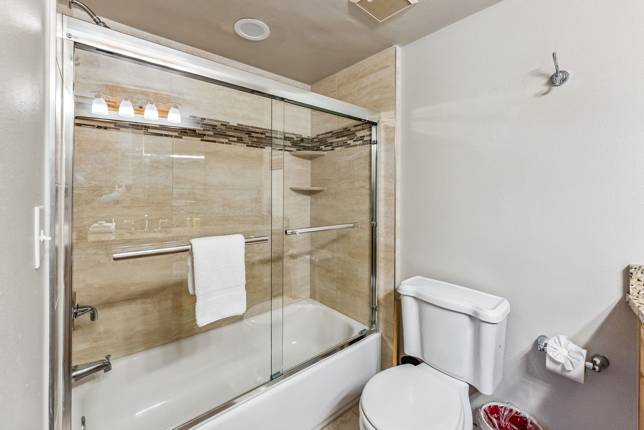 Ein modernes Badezimmer mit einer Duschkabine, einer weißen Badewanne und einer Toilette.