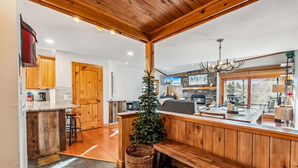 A cozy kitchen with wooden cabinets, a stone backsplash, and a built-in bench. - Ski-In/Walk-Out, Garage Parking, 2/2.5, Prime Location, Walk to Main and Lift (Breckenridge)