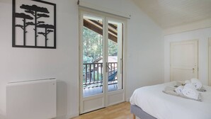 Camera da letto con un letto, un termosifone, una porta scorrevole in vetro che dà su un balcone e un'opera d'arte appesa al muro.