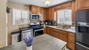A modern kitchen with wooden cabinets, stainless steel appliances, and a central island.