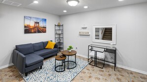 A modern living room with a gray sectional sofa, a round coffee table, and a patterned rug.