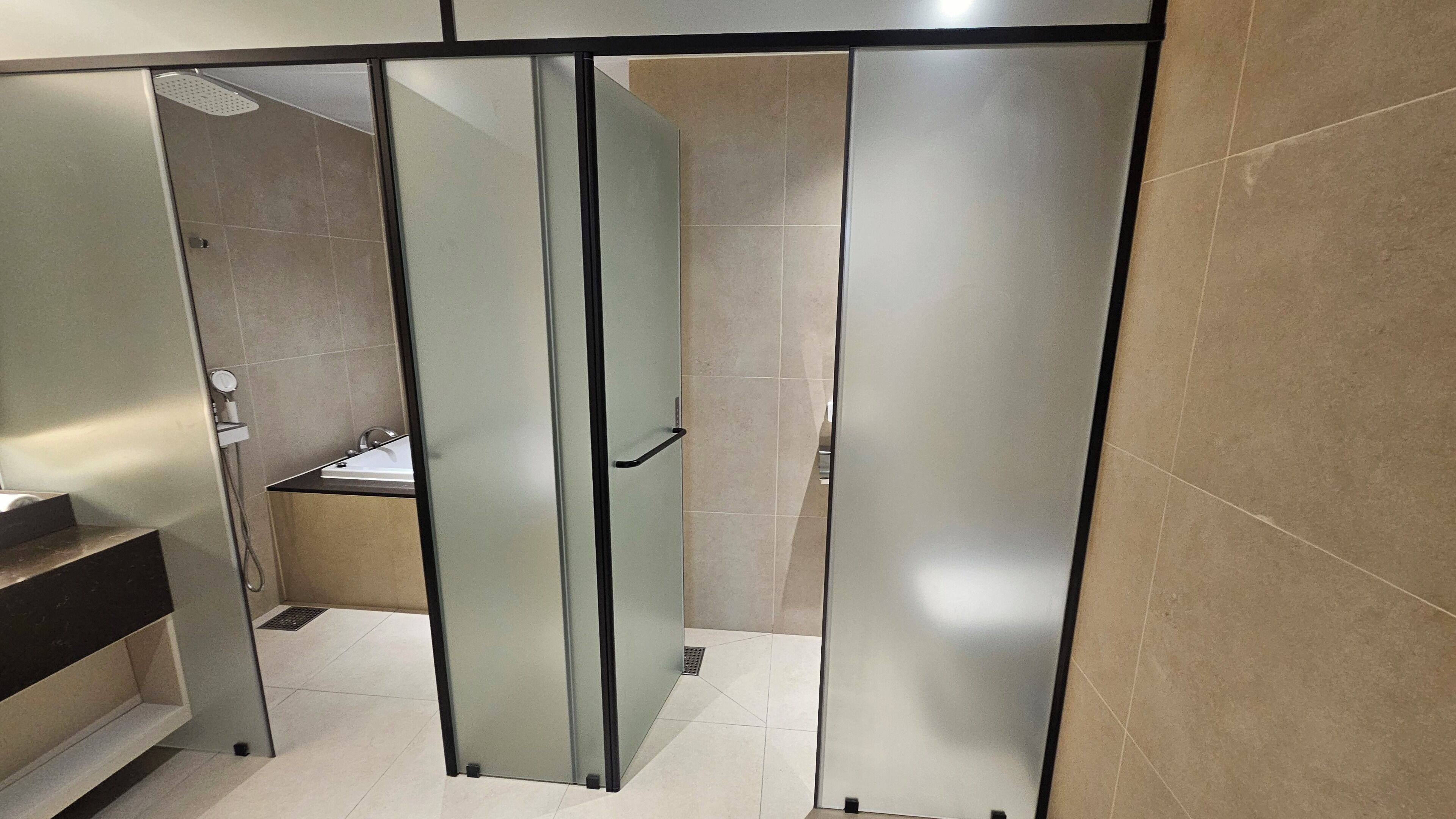 A modern bathroom with a glass partition, a sink, and a toilet.