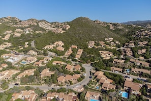 A residential area with houses on a hillside, roads, and a swimming pool. - On the stretch of coast between Santa Teresa di Gallura and Isola Rossa, in the north of Sardinia, lies the Costa Paradiso residential complex. The resort of Costa Paradiso is an oasis of tranquillity overlooking an <b>unspoilt natural landscape</b> and  (Trinita' d'Agultu e Vignola)