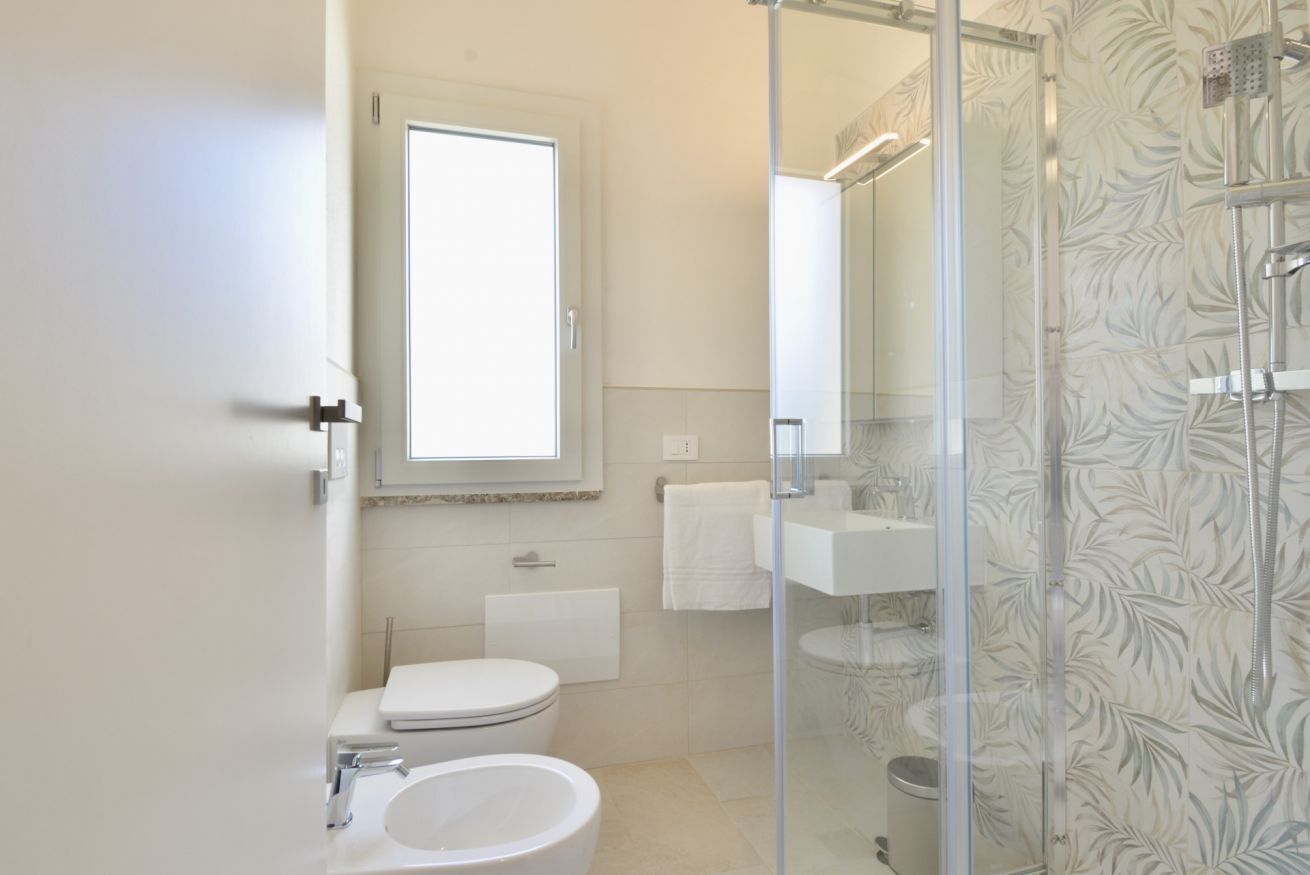 Un bagno con il water, lavandino e doccia.