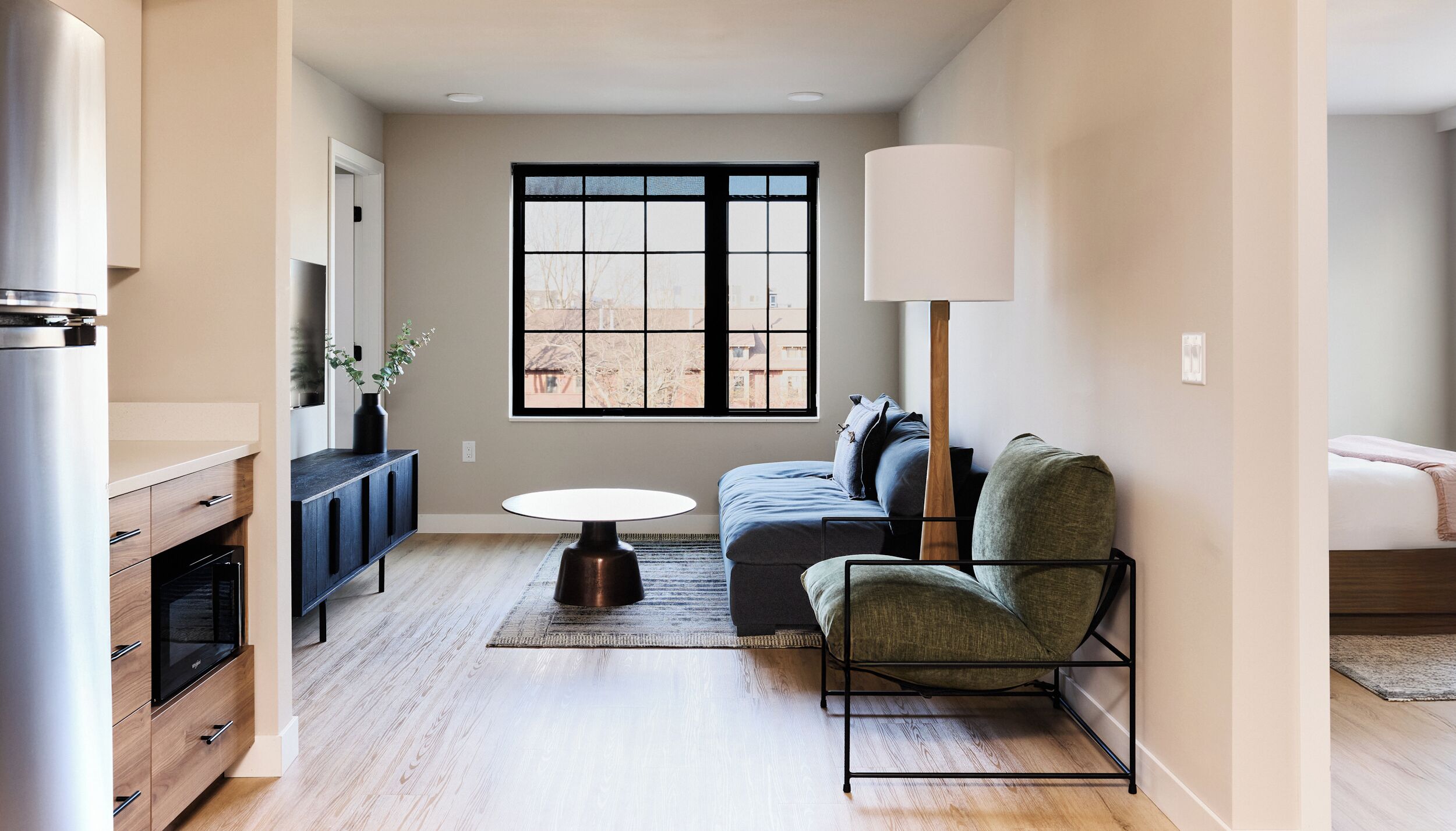 Un salon moderne avec un canapé, une table basse et une grande fenêtre.