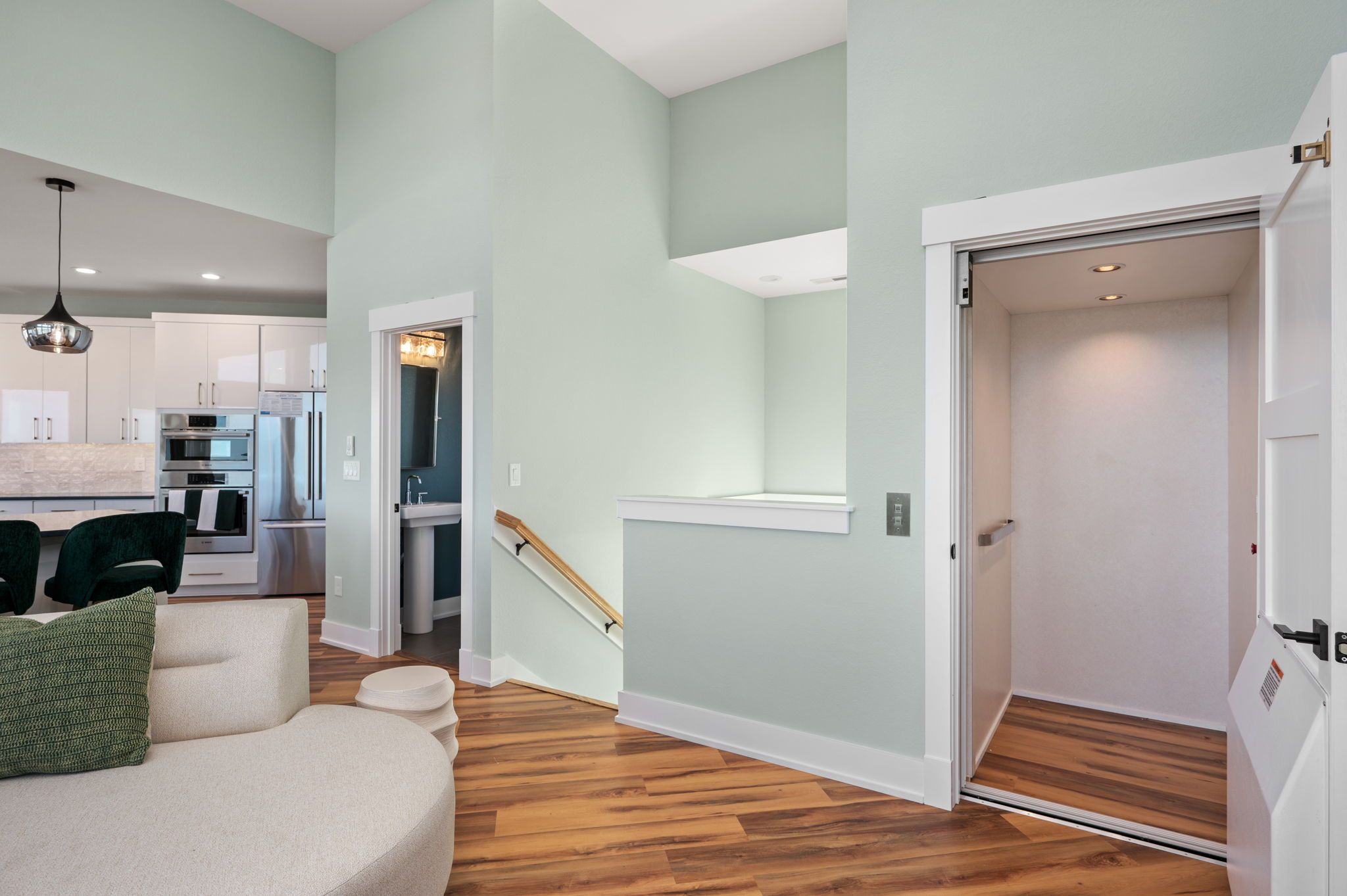 A modern apartment with a kitchen, living area, and a staircase leading to an upper floor.