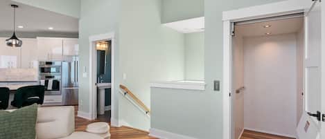 A modern apartment with a kitchen, living area, and a staircase leading to an upper floor.