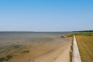 A beach with a wooden boardwalk leading to the water. - Kite Surf Cottage: Stunning Soundfront Home, Panoramic views of the Sound and Sunset (Nags Head)