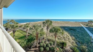 A balcony with a view of a beach and palm trees. - AFFORDABLE BEACHFRONT CONDO FOR FAMILIES (Orange Beach)