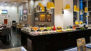 Un'area buffet con diversi tipi di cibo e una zona salotto con tavoli e sedie.
