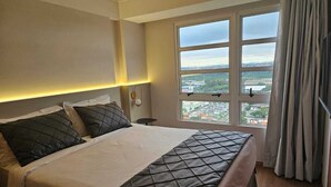 Una camera d'albergo con un letto grande, un comodino e una finestra con tende.