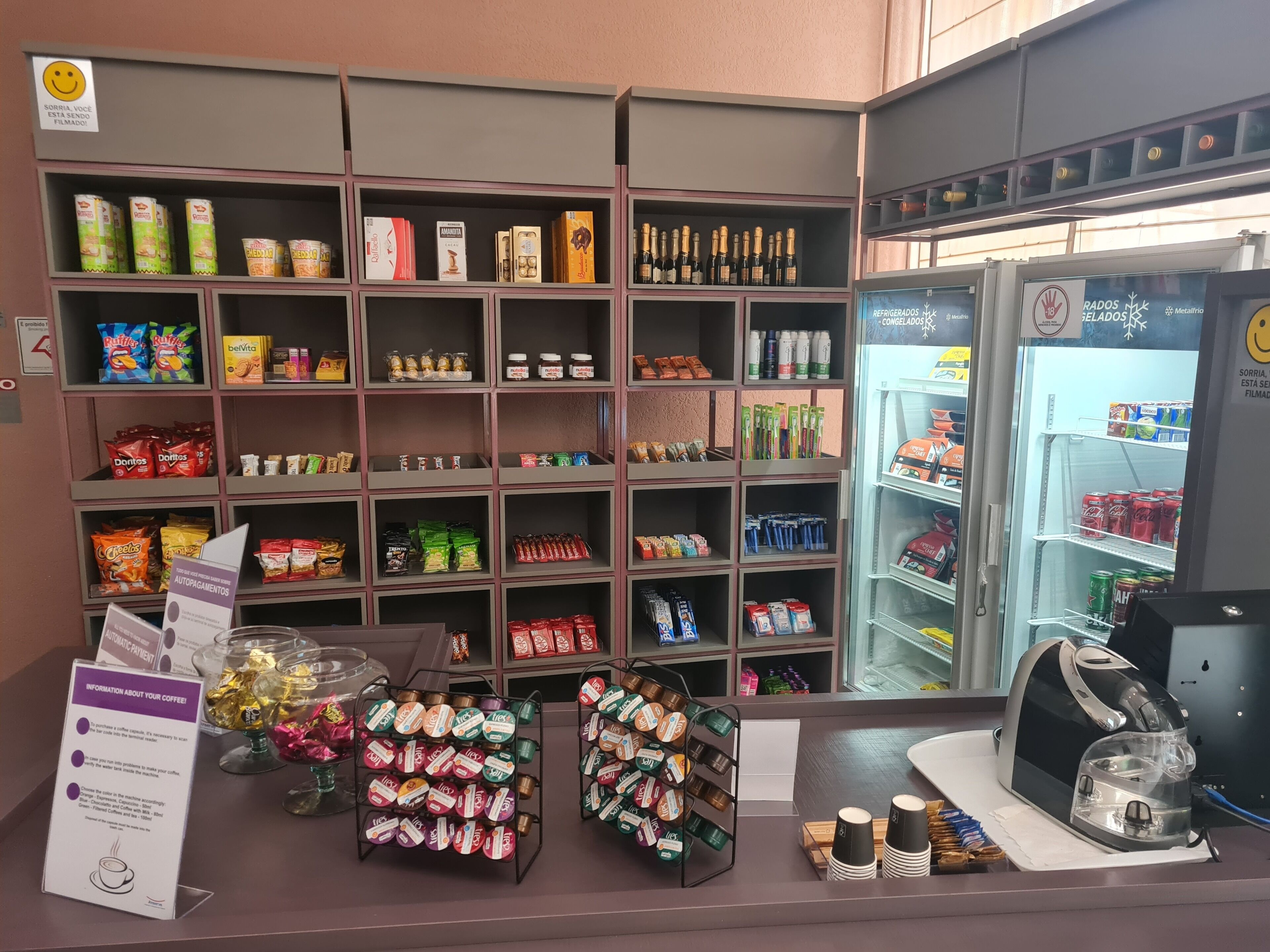 A snack and beverage display with various products including chips, chocolates, and bottled drinks.