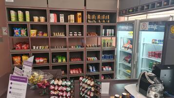 A snack and beverage display with various products including chips, chocolates, and bottled drinks.